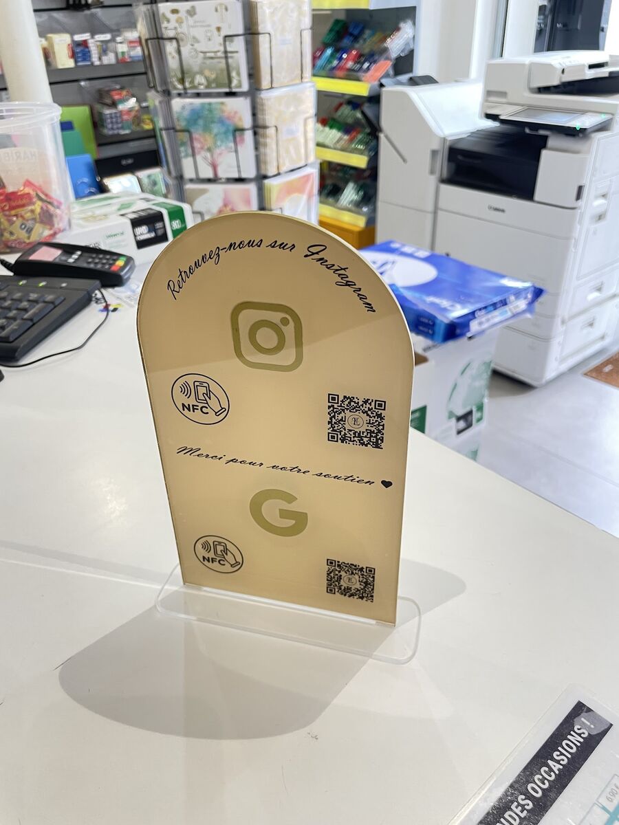Plaque arche dorée Instagram et Google avec NFC sur un comptoir — DPS Boulogne