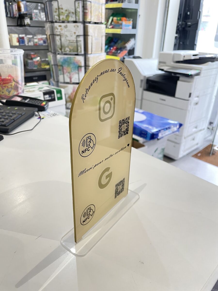 Plaque arche dorée Instagram et Google avec NFC sur un comptoir — DPS Boulogne